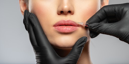Young caucasian woman getting botox cosmetic injection in the lips. Beautiful woman gets botox injection in her face. Adult girl gets cosmetic injection of botox in a clinic. Beauty treatments | Adam J Cohen, MD in Glenview & Chicago, IL