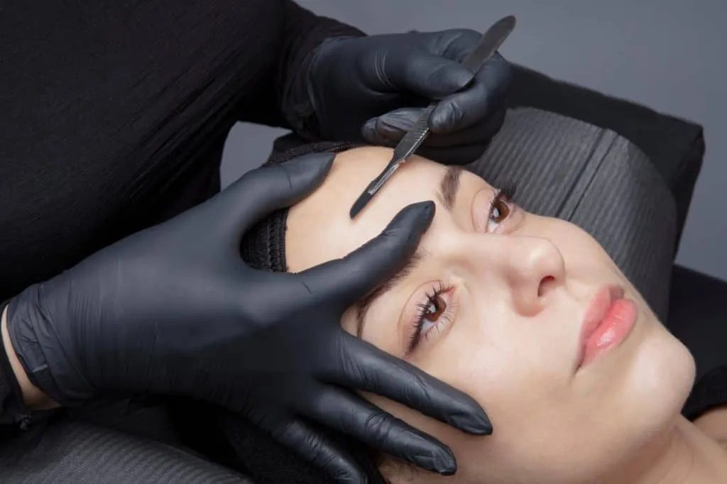 Cosmetologist in a beauty center performing a beauty treatment for the skin of the face with the dermaplaning technique. Aesthetic facials | Adam J Cohen, MD in Glenview & Chicago, IL