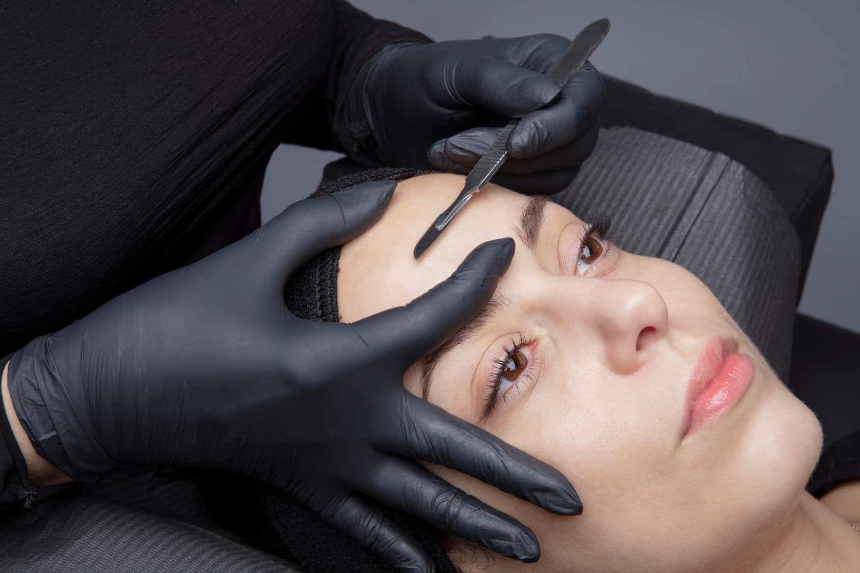 Cosmetologist in a beauty center performing a beauty treatment for the skin of the face with the dermaplaning technique. Aesthetic facials | Adam J Cohen, MD in Glenview & Chicago, IL