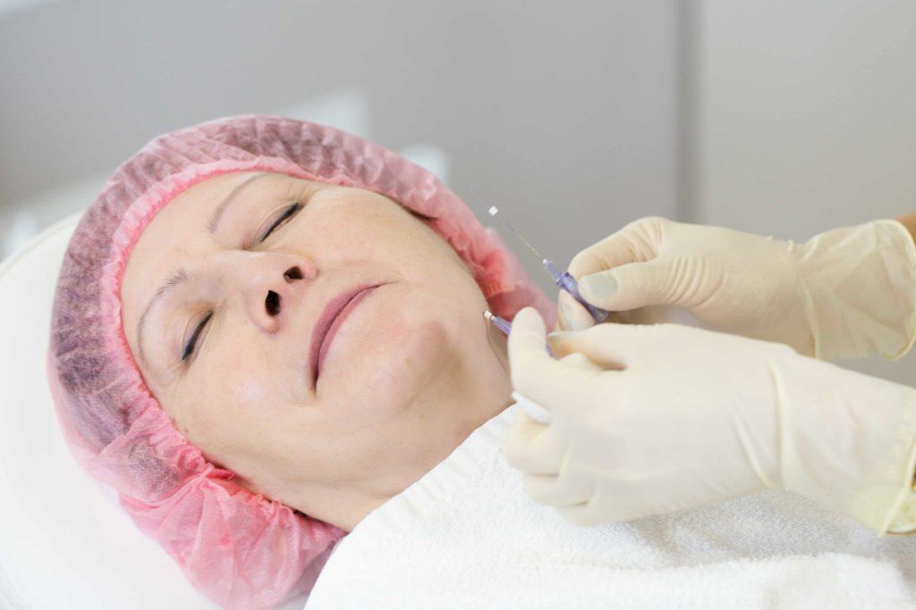 Beautiful mid aged woman getting polydioxanone thread lifting at beauty salon | Adam J Cohen, MD in Glenview & Chicago, IL