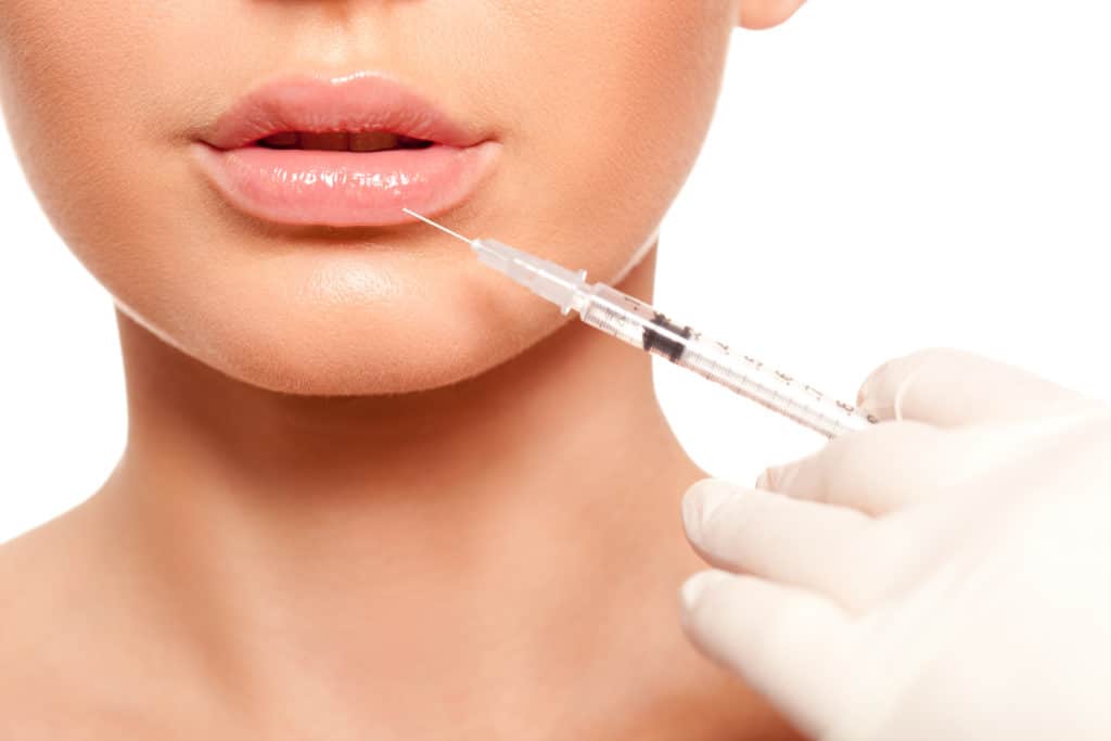 Closeup beautiful woman face, syringe injection to lips beauty concept | Adam J Cohen, MD in Glenview & Chicago, IL