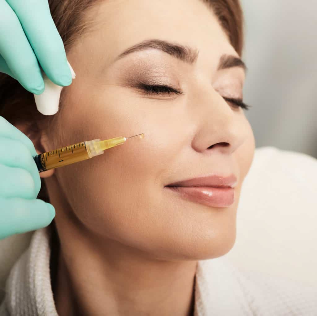 Adult beautiful woman during facial PRP therapy. Beautician doing blood plasma injection for patient face skin cell restoration, close-up | Adam J Cohen, MD in Glenview & Chicago, IL