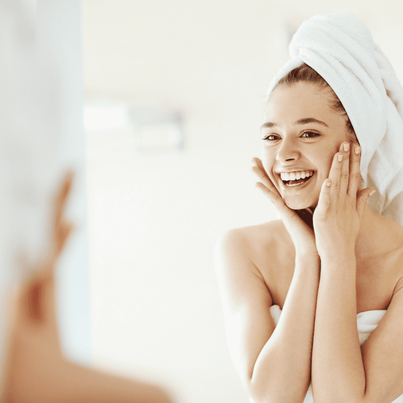 Beautiful young woman with clean perfect skin. Portrait of beauty model with natural nude make up and touching her face. Spa, skincare and wellness. Close up | Adam J Cohen, MD in Glenview & Chicago, IL