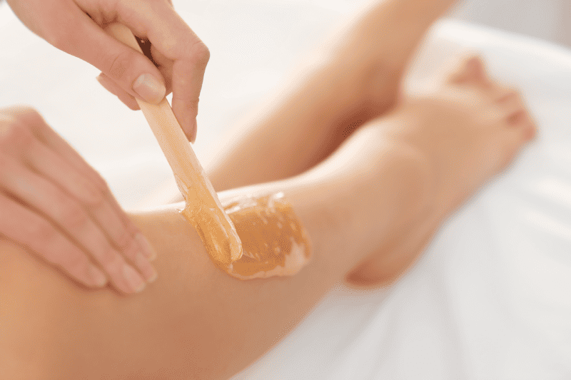 Leg hair epilation or waxing procedure done at modern wellness salon by a woman | Adam J Cohen, MD in Glenview & Chicago, IL